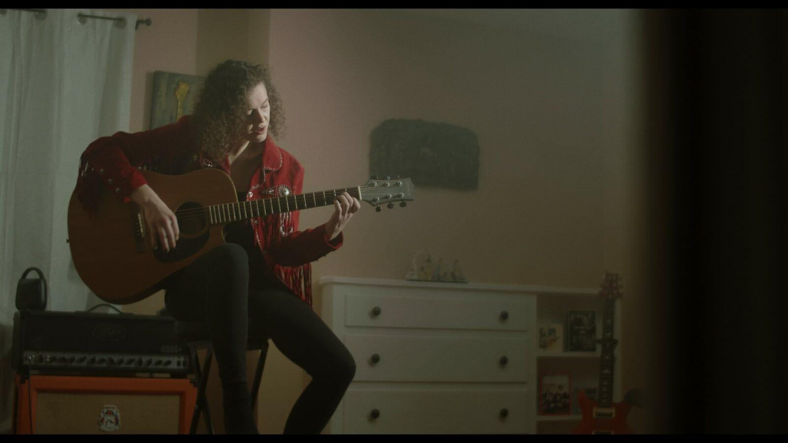 A woman play a guitar